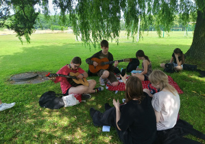 Uczniowie grają na gitarze
