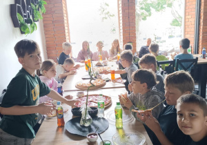 Uczniowie kl. IVc jedzą pizzę.