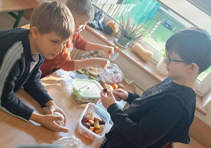 Uczniowie robią sałatkę.