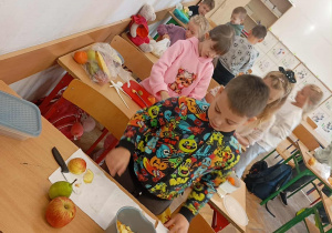 Uczniowie robią sałatkę.